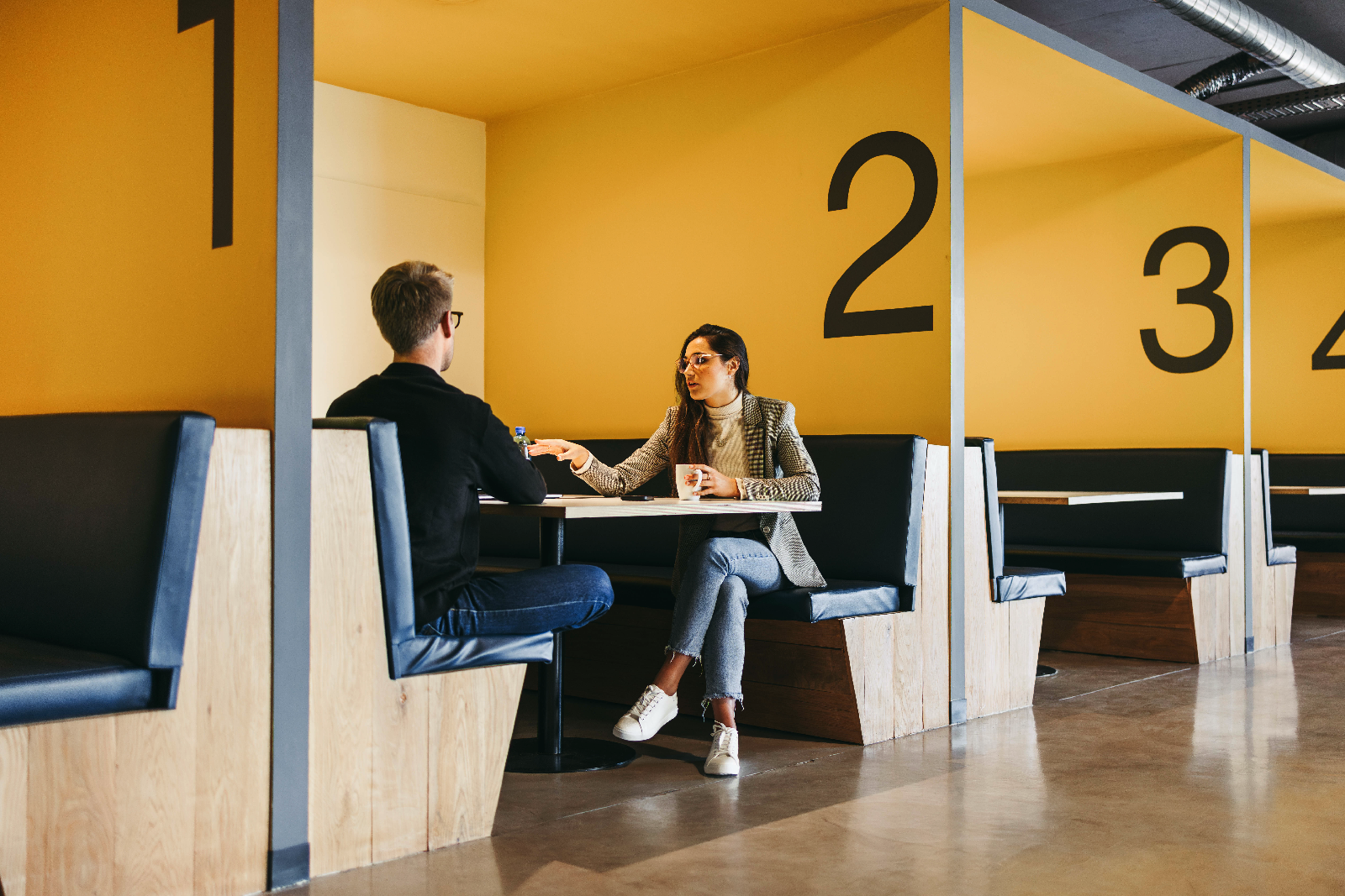 Zwei Entwickler besprechen eine Projektplan in einem Meeting Space eines modernen Büros