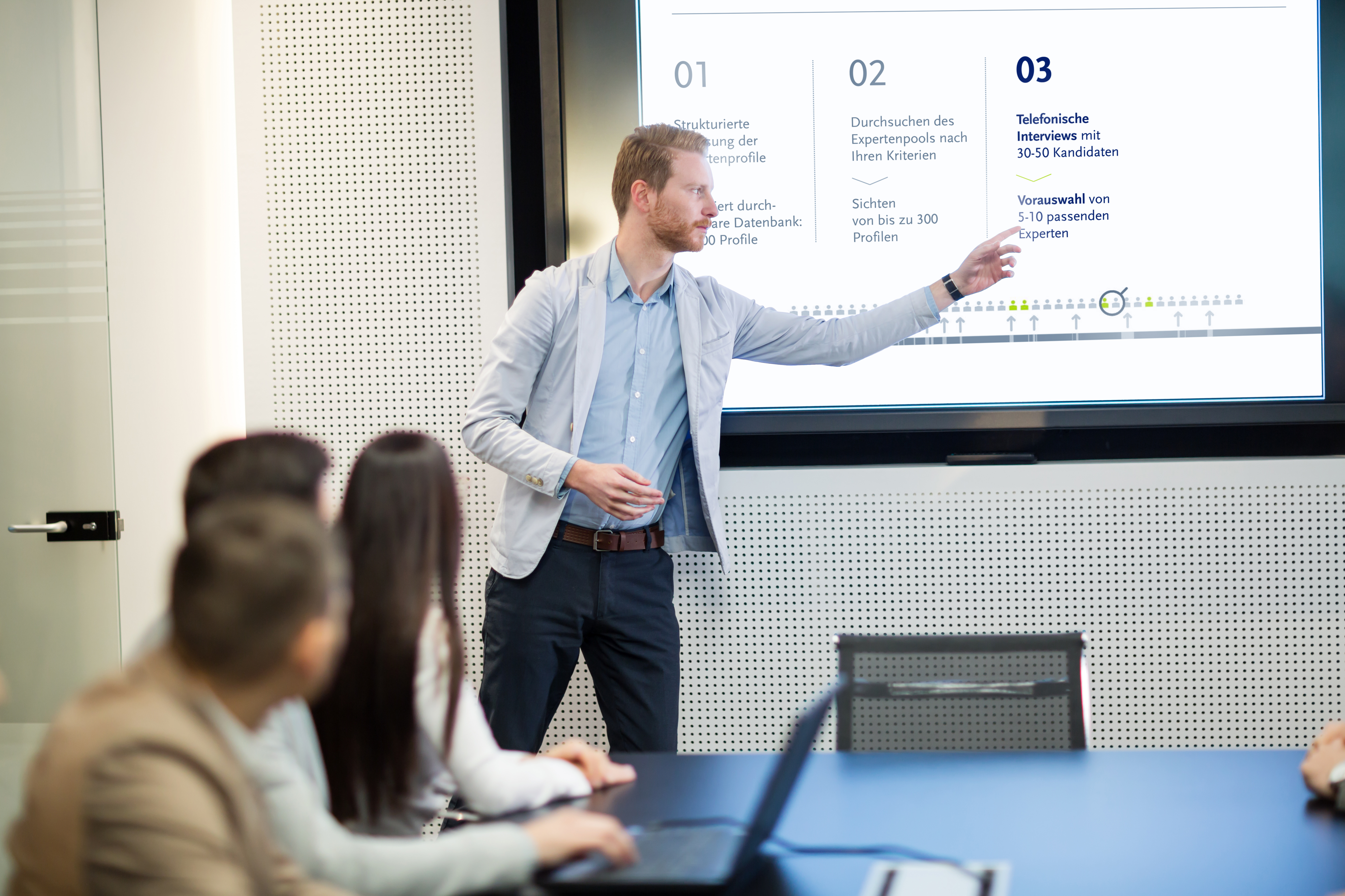 Account Manager hält vor Kunden Präsentation am Beamer
